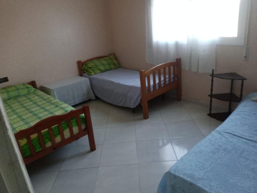 Aït SaïdにあるKing’s Bergementのベッド2台と窓が備わる小さな客室です。