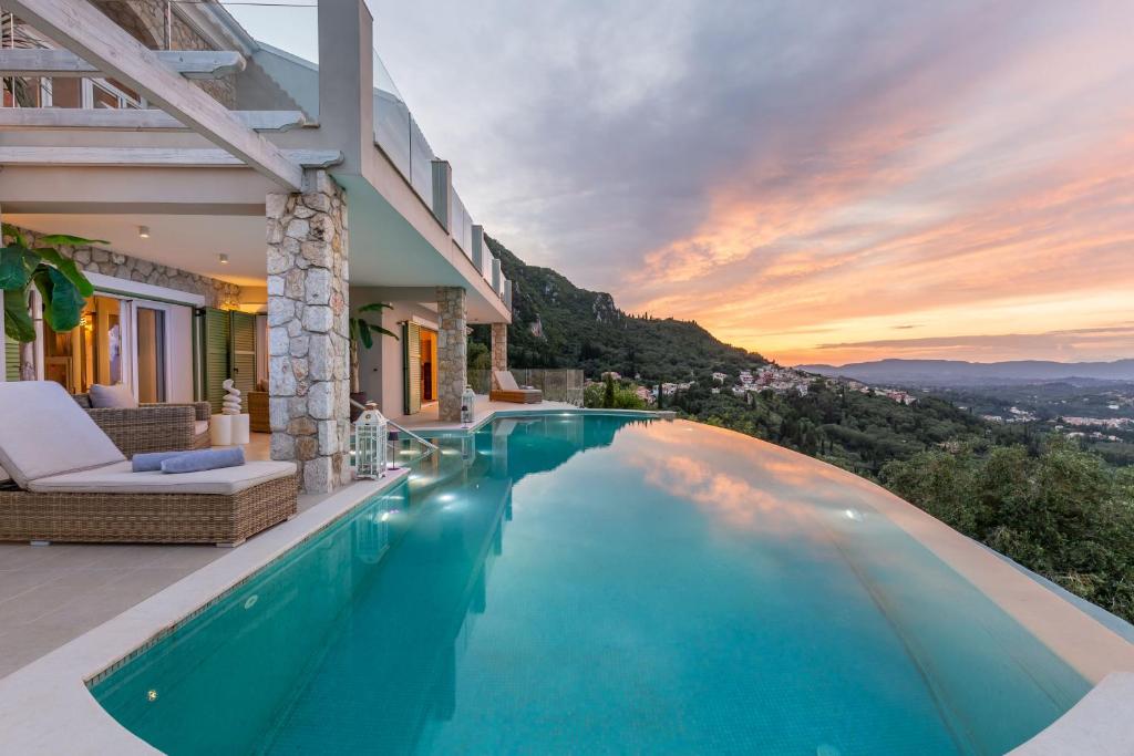a villa with a swimming pool and a sunset at Villa Nirvana in Áyioi Dhéka