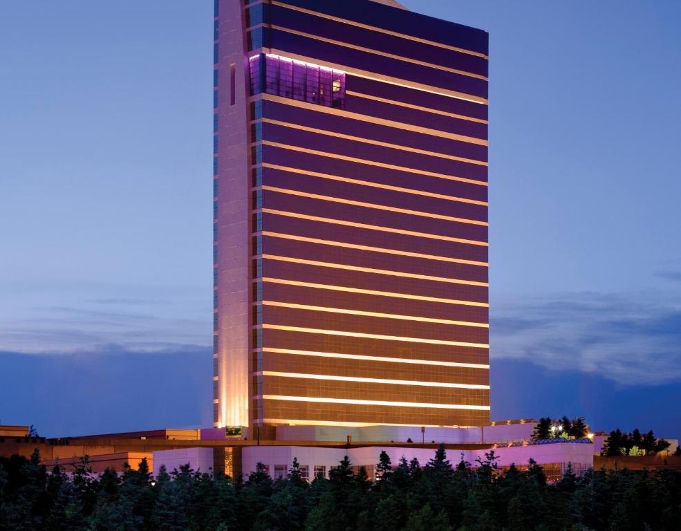 Un grand bâtiment avec des lumières allumées devant lui dans l'établissement MGM Tower at Borgata, à Atlantic City