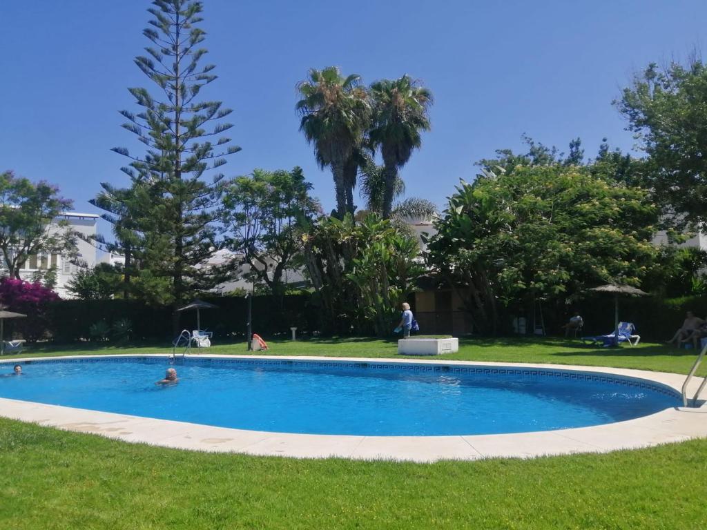 una piscina en la hierba con gente nadando en ella en Playa San Miguel, en Cartaya