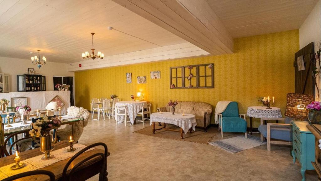 Külaliskorter في Padise: غرفة بها طاولات وكراسي وجدران صفراء