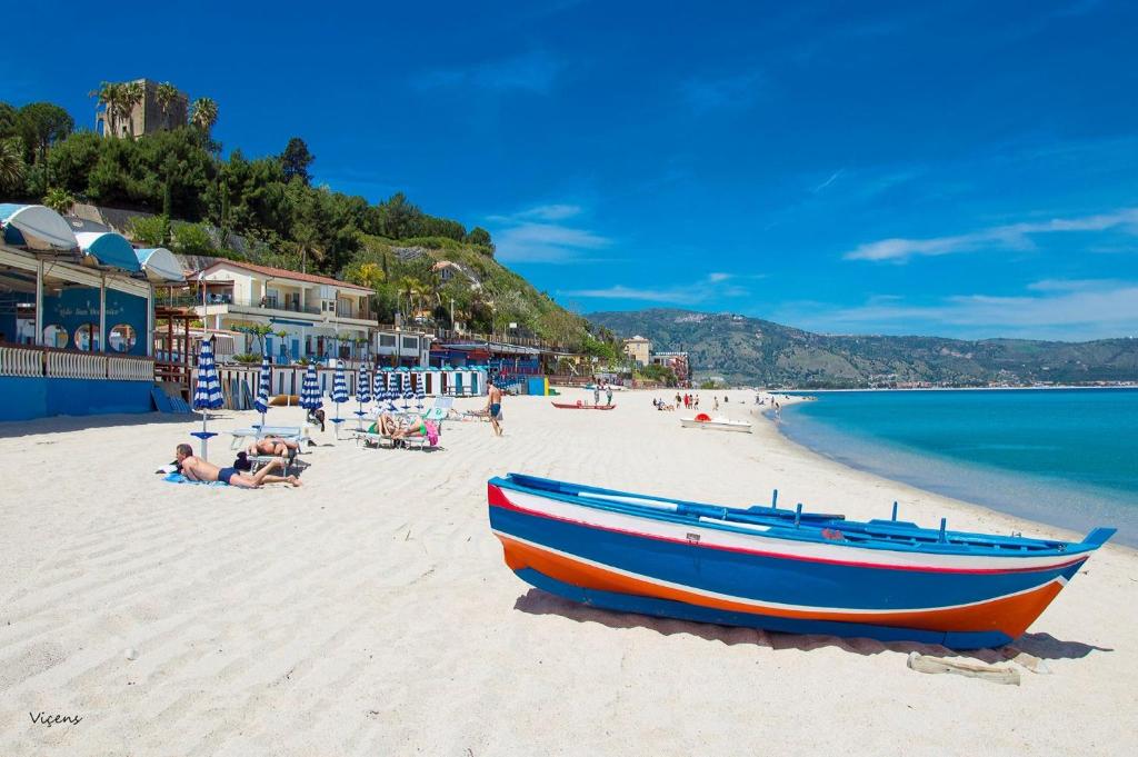 a blue and orange boat sitting on a beach at Il Nocchiero City Hotel in Soverato Marina