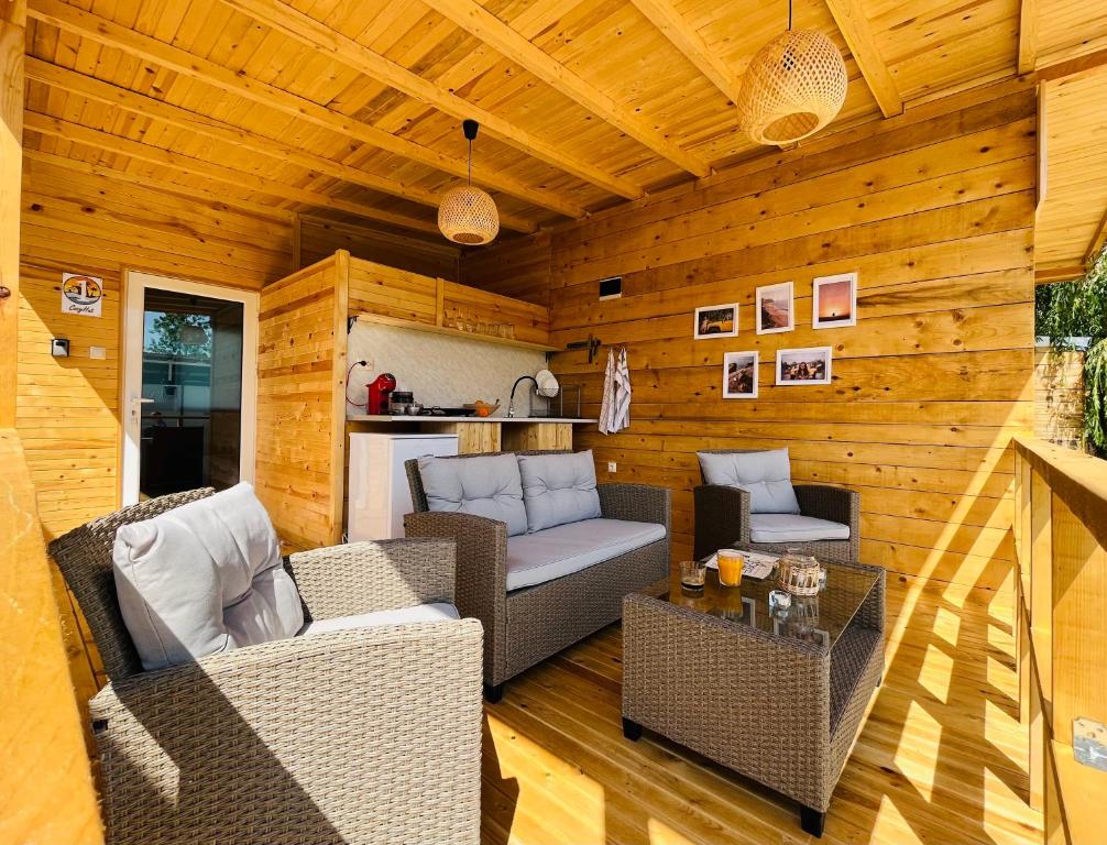 a patio with wicker chairs and a table in a cabin at CozyHut Бунгало под Наем in Chernomorets