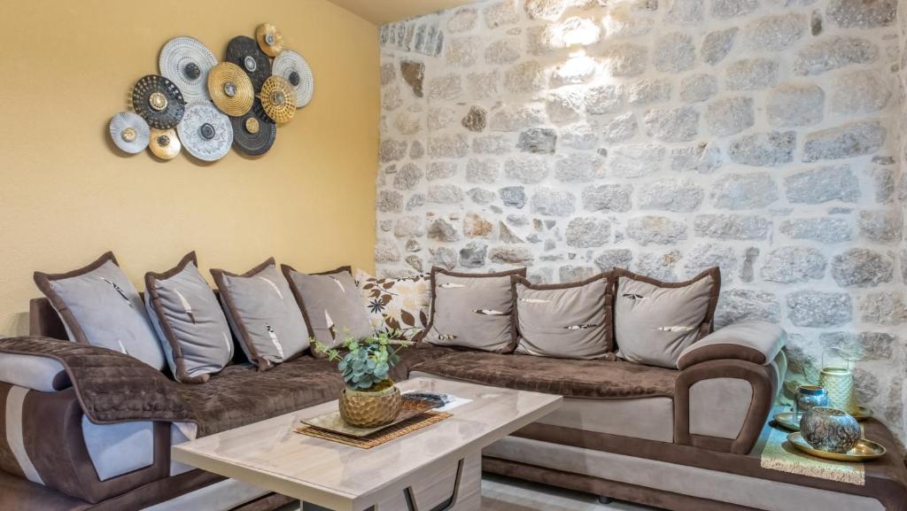 a living room with a couch and a stone wall at Authentic Vacation Flat Near Beach in Kotor in Kotor