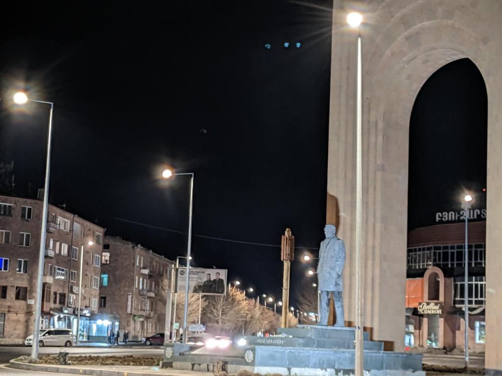 uma estátua em frente a um monumento à noite em Movsisyan guest house em Guiumri