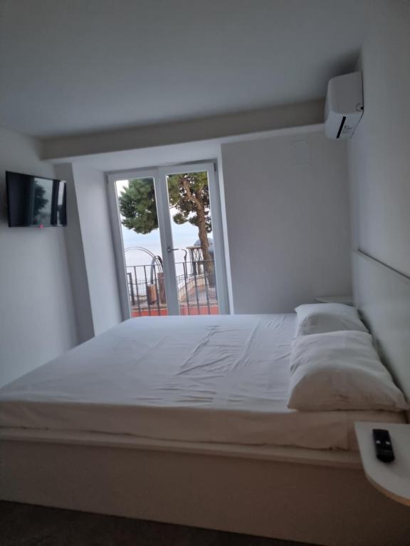 una camera da letto con un grande letto bianco e una finestra di Il Panorama a Vietri