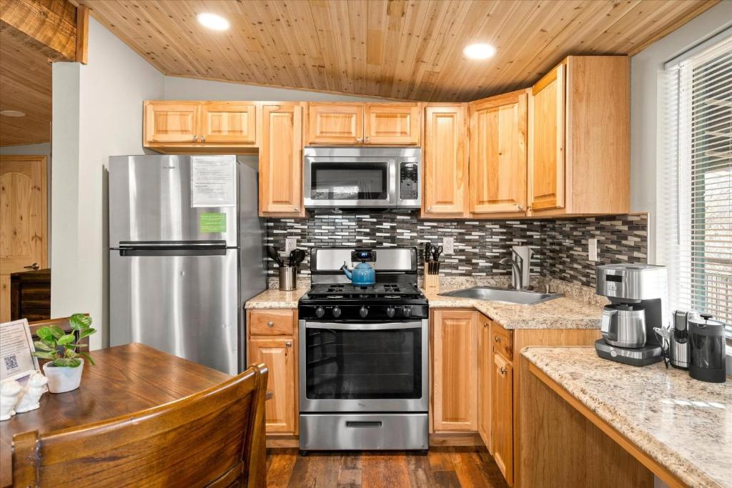 uma cozinha com armários de madeira e electrodomésticos de aço inoxidável em Creekside Retreat 18 condo em Sedona