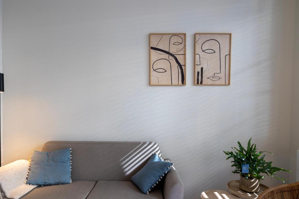 Huys17 في هاسيلت: غرفة معيشة مع أريكة وصورتين على الحائط