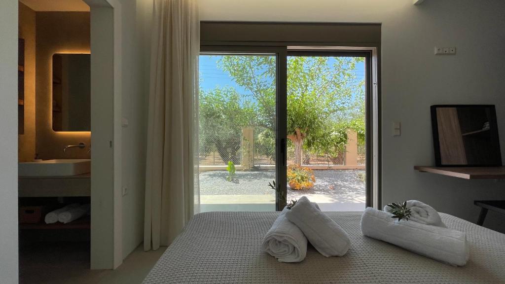 a bedroom with a bed and a bathroom with a window at Lagouvardos Beach House in Marathopolis