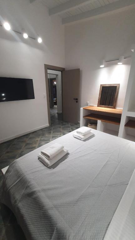 a white room with a bed with two towels on it at AQUA VILLA in Selínia
