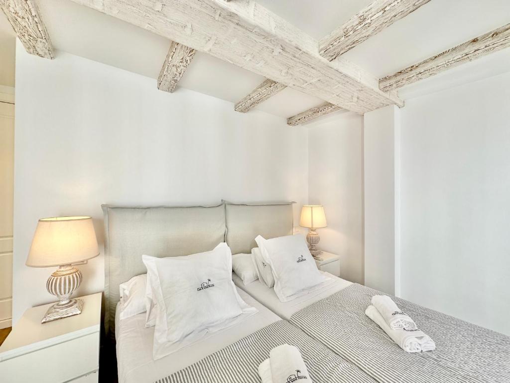 1 dormitorio con paredes blancas y 1 cama con almohadas blancas en Old Town Modern Flat, 4 Minutes From Beach - EaW Homes en Marbella