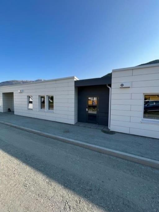 a large white building with windows on the side of a road at Studio Leiligheit in Sogndal