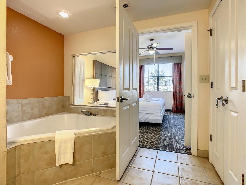 ein Badezimmer mit Badewanne und ein Schlafzimmer in der Unterkunft Vacation Villa At Orlando Resort in Orlando