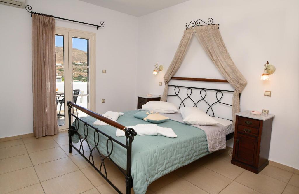 a bedroom with a large bed and a balcony at Villa Andromeda in Amorgos