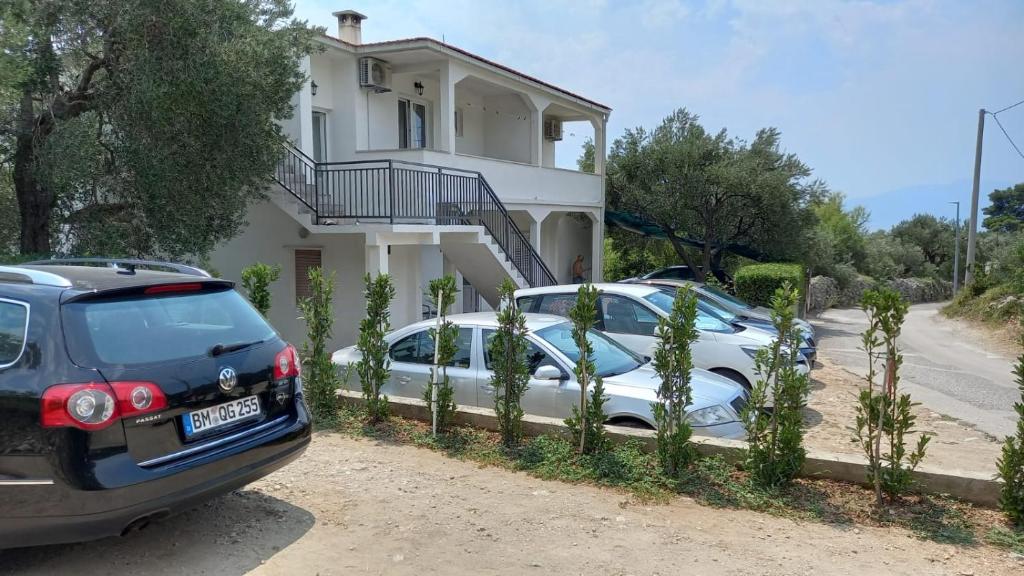 dwa samochody zaparkowane przed domem w obiekcie Studio apartmani Ante w mieście Zaostrog