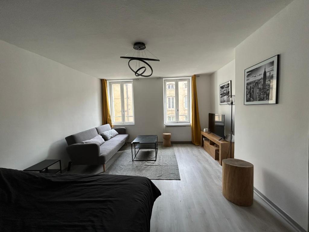 un salon avec un canapé et une télévision dans l'établissement Le Poincaré, à 1 min de la gare, à Nancy