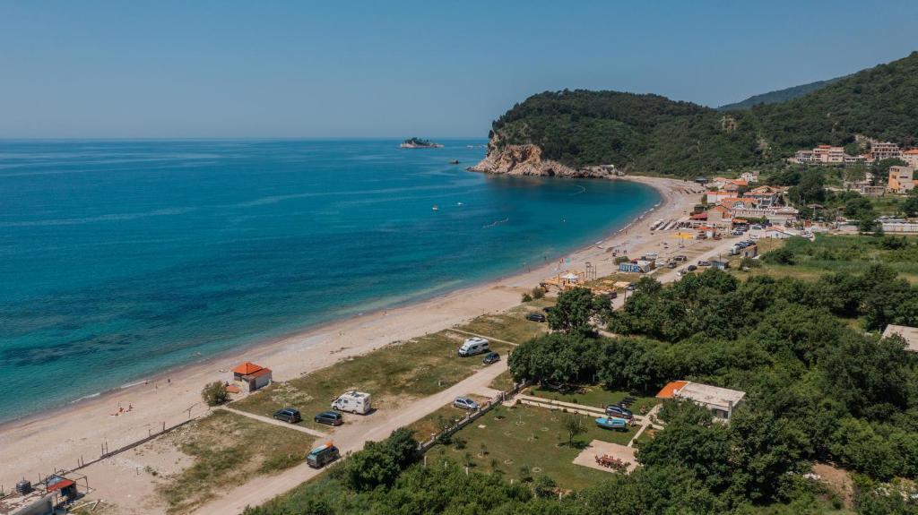 une vue aérienne sur une plage avec des voitures garées dans l'établissement Holiday Home Sea, à Petrovac na Moru