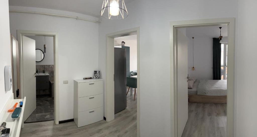 een slaapkamer met witte muren, een wit dressoir en een bed bij Boutique apartments 1 in Sînpetru