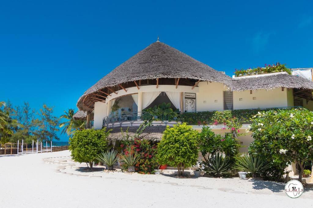 a house on the beach with plants and flowers at Baobab on the sand Apartment in Watamu