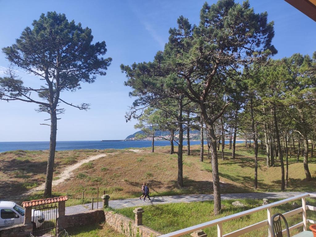 a person walking down a path next to a beach at Casa Velay in Fisterra