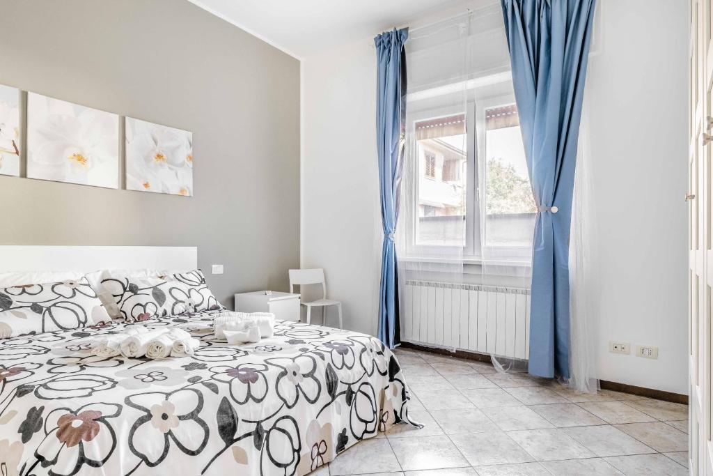 Schlafzimmer mit einem Bett und einem Fenster mit blauen Vorhängen in der Unterkunft Casa Vacanza via Sottocorno in Busto Arsizio