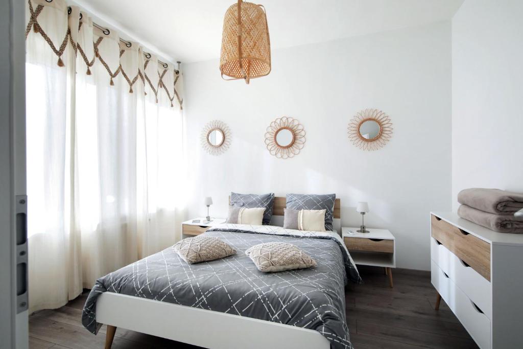 una camera da letto con un letto e due specchi sul muro di L'instant T 4* Balnéo, Sauna et Parking Privé a Colmar