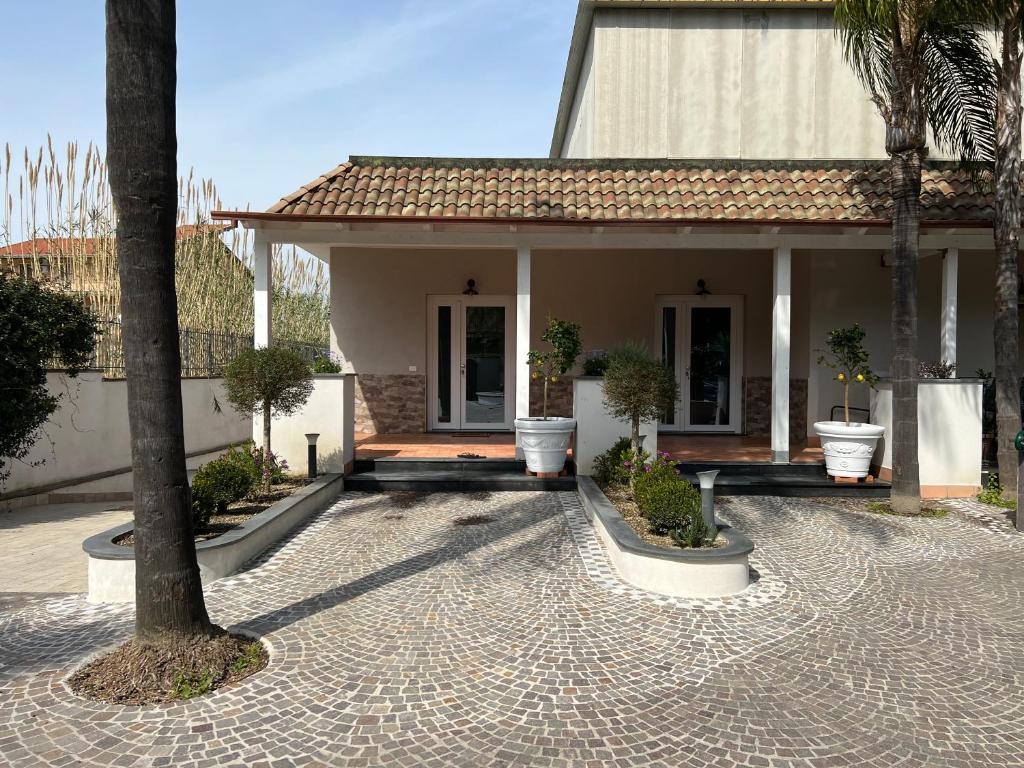 une maison avec un palmier en face dans l'établissement Villa Donnarumma, à Castellammare di Stabia
