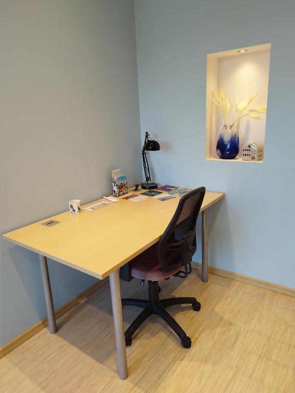 a wooden desk with a chair in a room at Spacious & Cozy Apartment with Forest View in Zapyškis