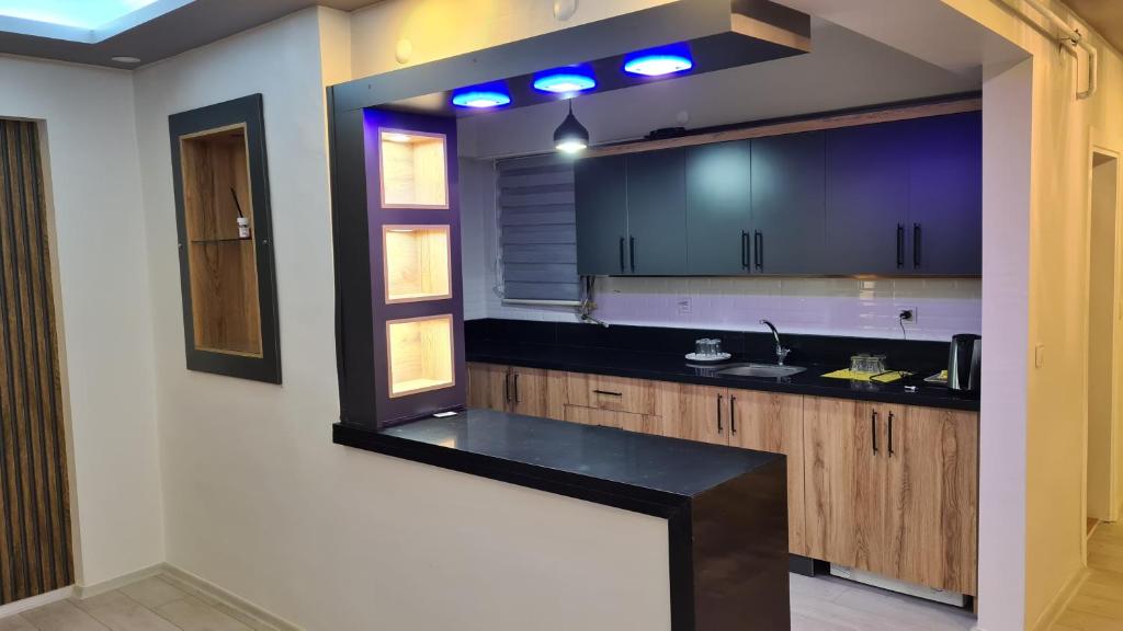 a kitchen with purple cabinets and a black counter top at Peri suit evleri in Tunceli