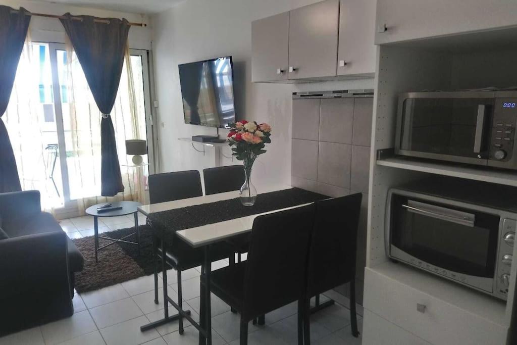 une cuisine avec une table avec un vase de fleurs dessus dans l'établissement Appartement en Bord de mer - Côte d'Azur, à Villeneuve-Loubet
