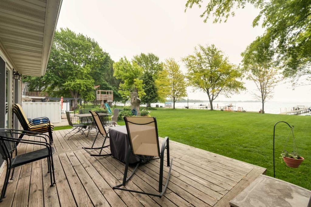 une terrasse avec des chaises et une table offrant une vue sur l'eau dans l'établissement Waterfront Johnson Lake Getaway with Fire Pit!, 