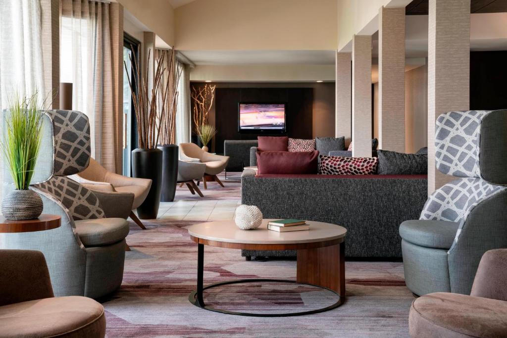 a lobby with couches and chairs and a table at Courtyard by Marriott San Francisco Airport in San Bruno
