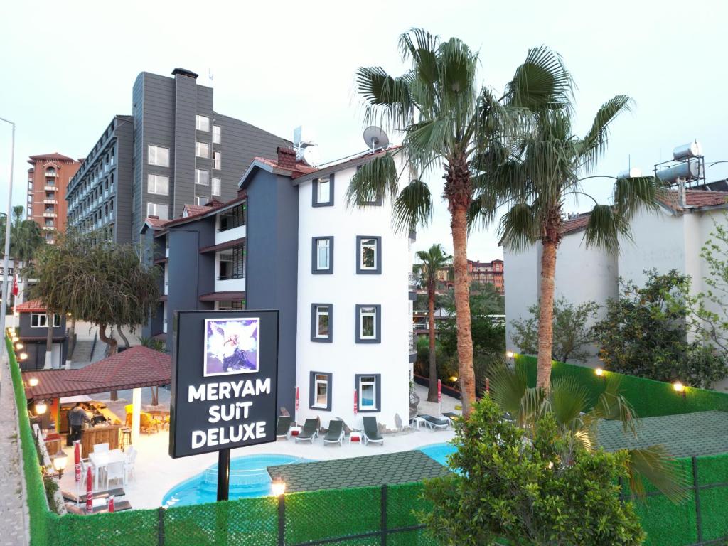 a sign in front of a white building with a hotel at MERYAM SÜİT DELUXE in Side