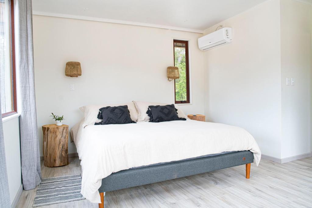 a white bedroom with a bed and a window at Tiny Houses Casablanca in Casablanca
