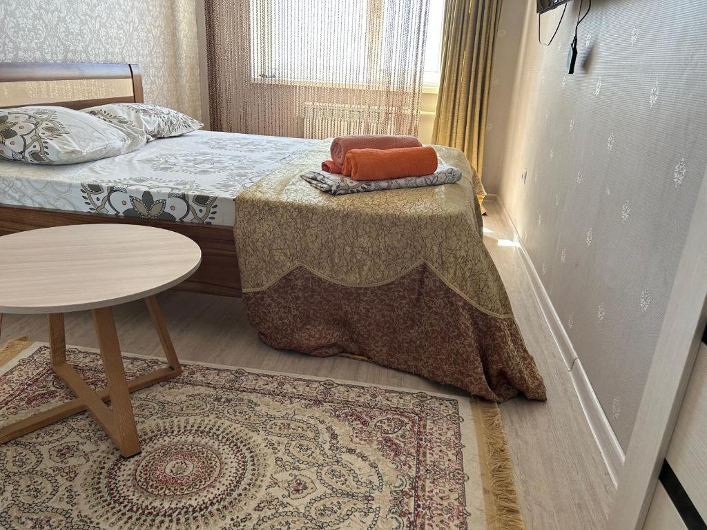 Dormitorio pequeño con cama con mesa y alfombra en 14-38 вид на море лучший район, en Aktau