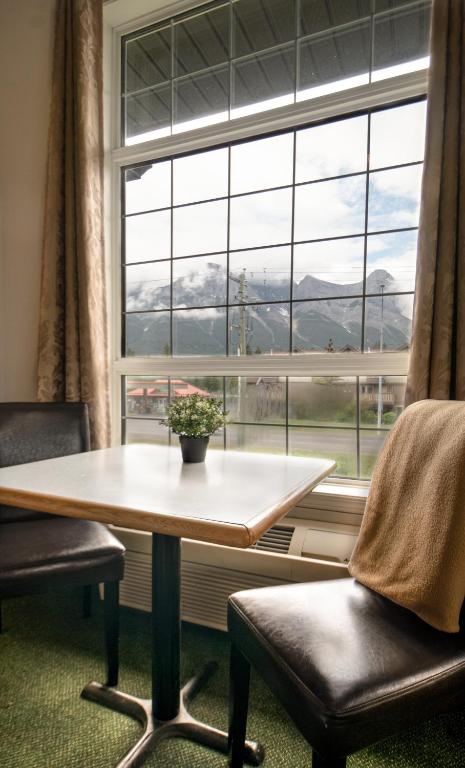 a table and two chairs in front of a window at Mountain View Inn in Canmore