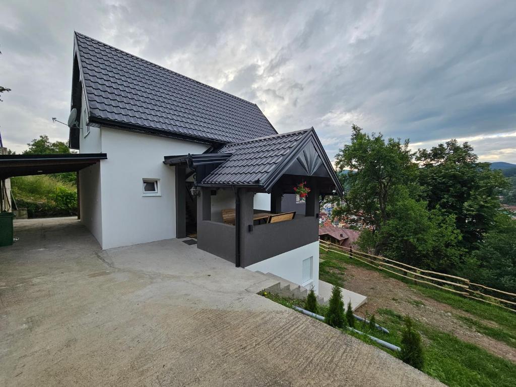 une petite maison blanche avec un toit noir dans l'établissement City View House, à Bijelo Polje