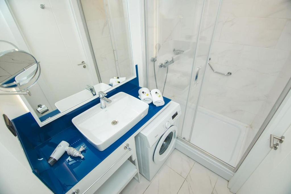 a bathroom with a sink and a shower at Orbi siti in Batumi