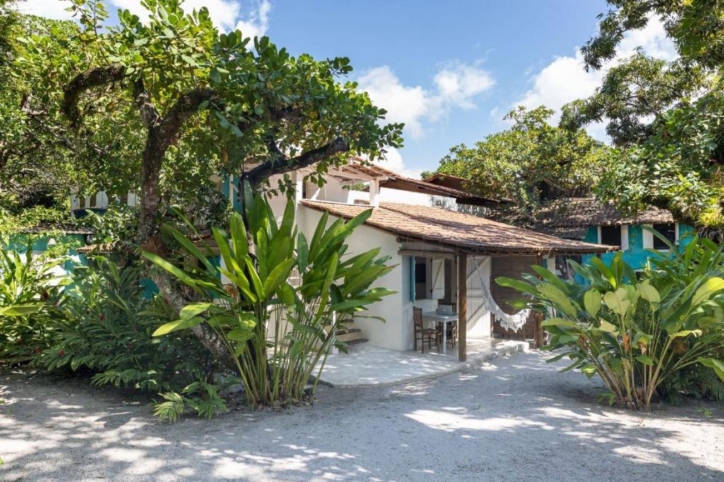 une maison sur la plage avec des arbres et des plantes dans l'établissement Pousada Villa Serena, à Caraíva