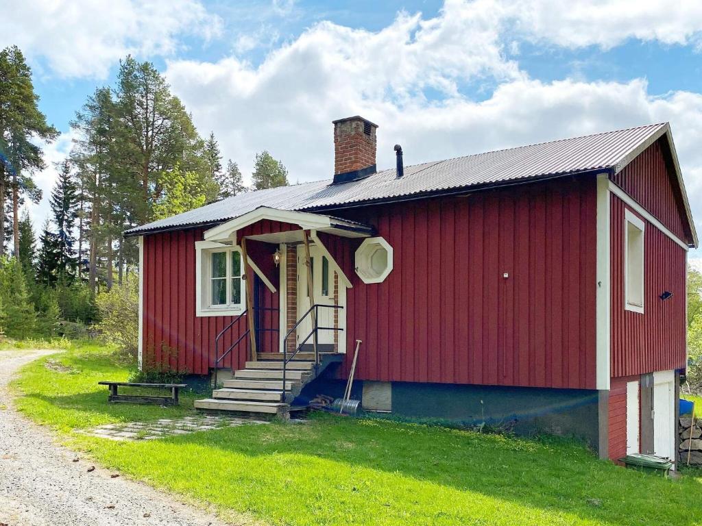 uma pequena casa vermelha com um alpendre e escadas para ela em Holiday home Svenstavik em Svenstavik