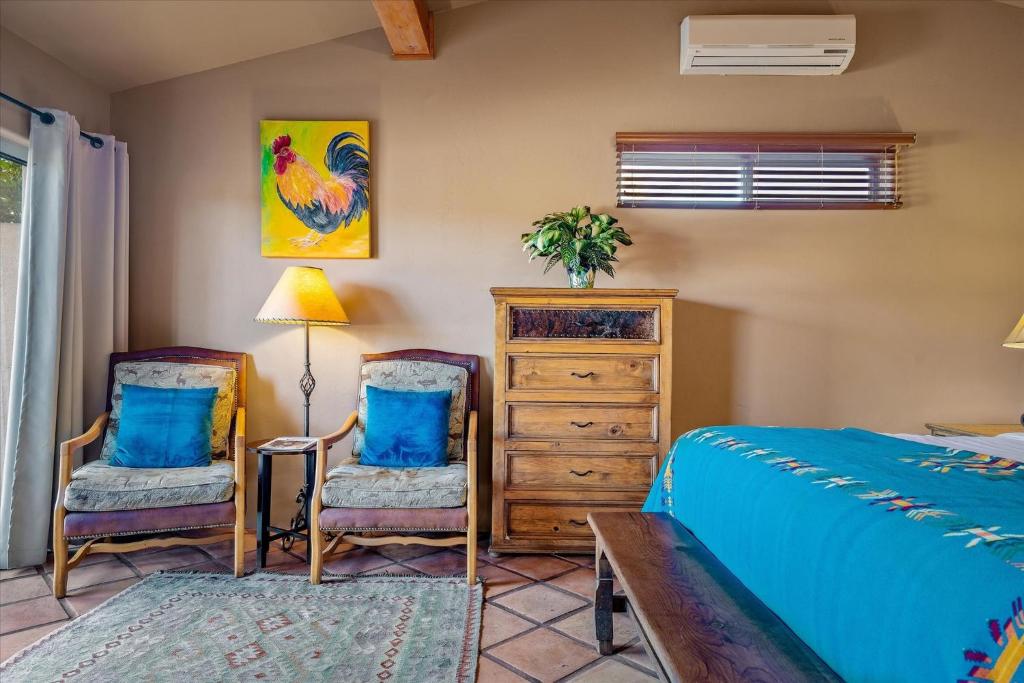 a bedroom with two chairs and a bed and a dresser at Adobe Hacienda in Sedona