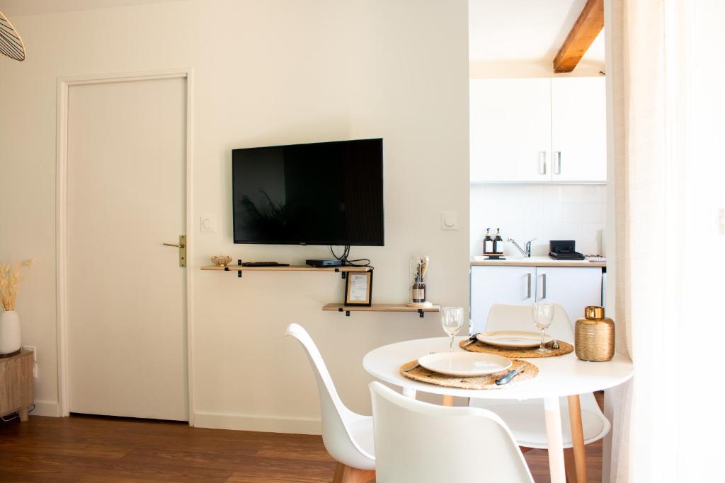 uma sala de jantar branca com uma mesa e cadeiras brancas em Appartement Tolosa em Toulouse