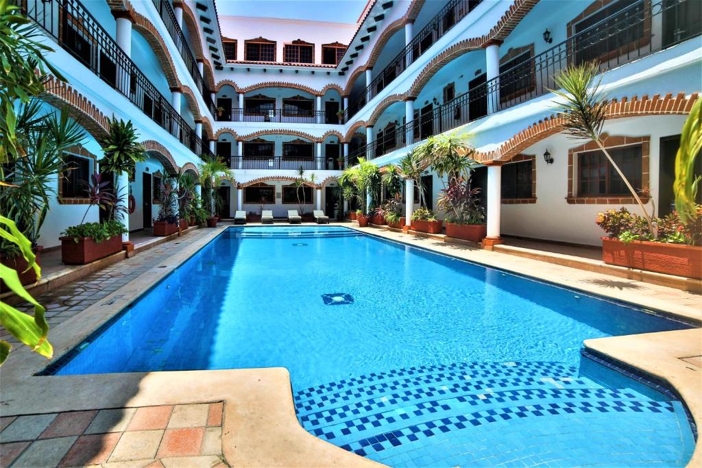 Hotel Colonial Playa del Carmen في بلايا ديل كارمن: مسبح وسط مبنى