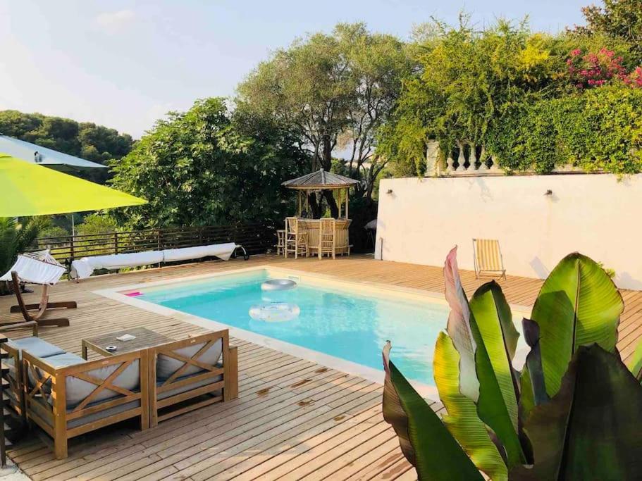 - une piscine avec une terrasse en bois dans l'établissement Magnifique villa Antibes, à Antibes