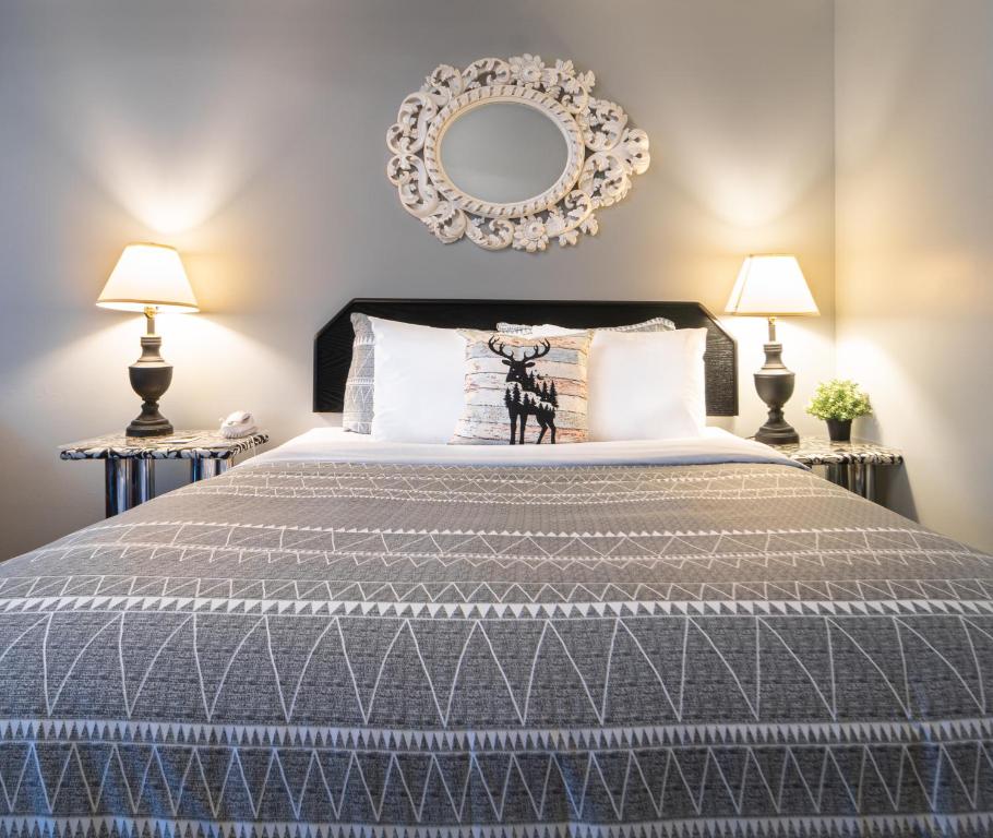 a bedroom with a large bed with two lamps at Mountain View Inn in Canmore