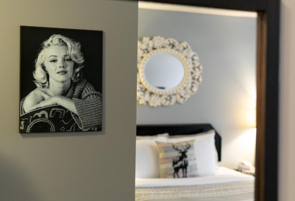 a mirror in a room with a picture of a woman at Mountain View Inn in Canmore
