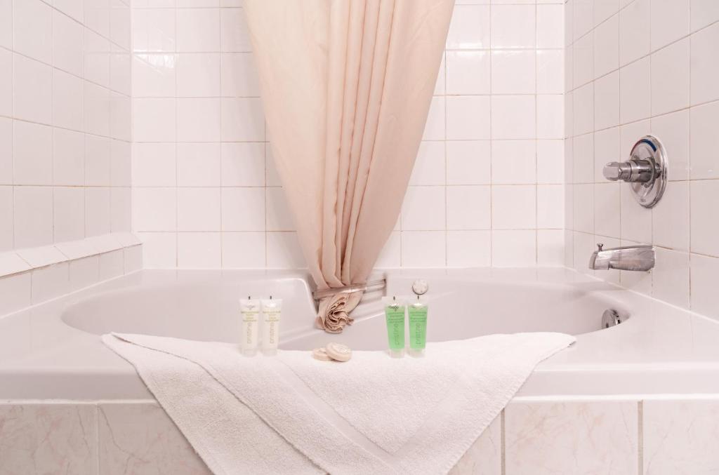 a white bath tub with a towel and two candles at Mountain View Inn in Canmore