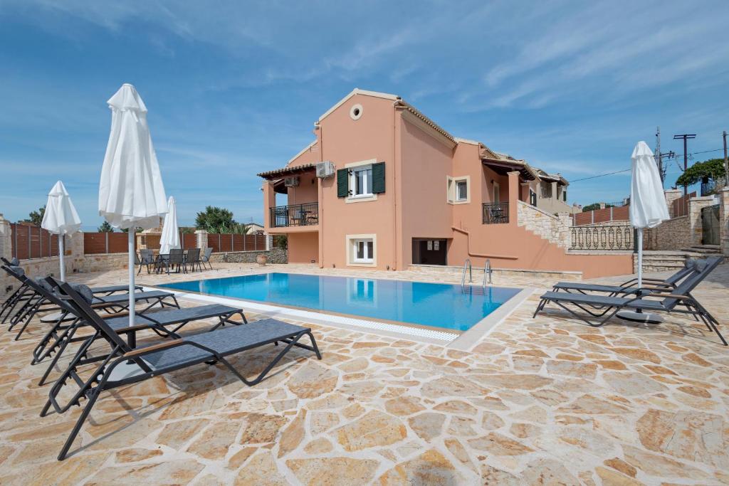a villa with a swimming pool and patio furniture at Mano's pool villa in Potamós