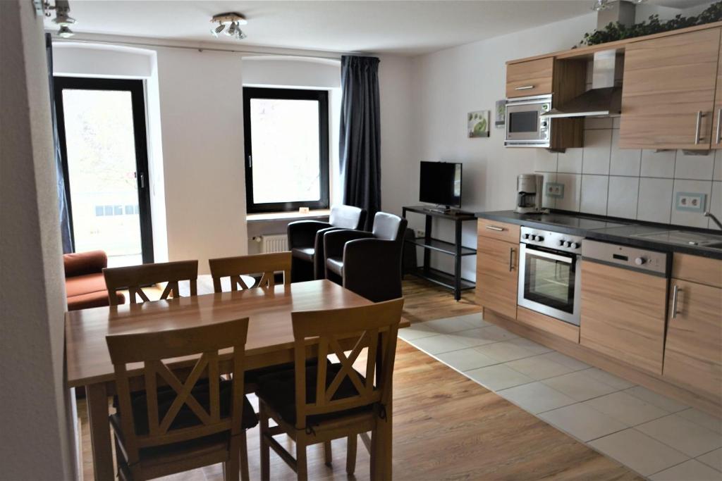 uma cozinha e sala de jantar com mesa e cadeiras em App-4-Pers-2-Schlafzimmer-mit-eigenen-Badezimmer-2-Balkonen-alle-mit-Moselblick em Ediger-Eller