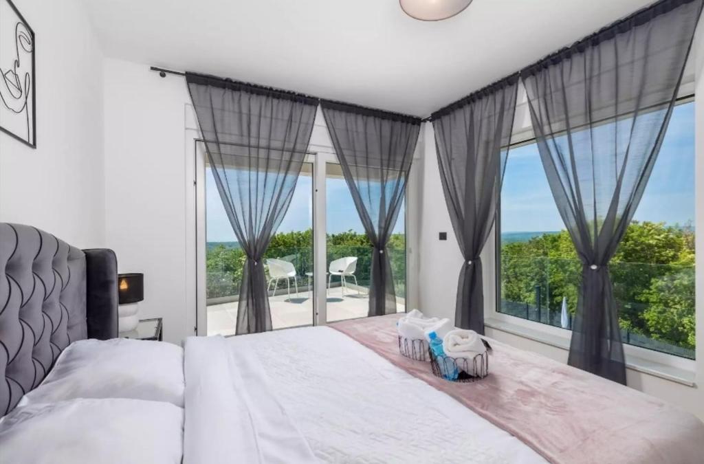 a bedroom with a large bed and a large window at Villa La Vie in Garica